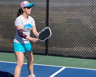 Ellen playing pickleball on an outdoor court, showcasing active Smart Dinker coaching in action.