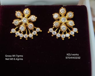 a pair of gold toned earrings with diamonds