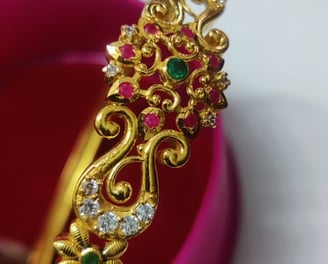 a gold bangle and a pink bracelet