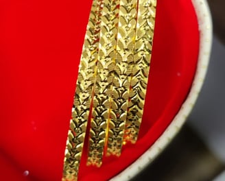 a red bowl with gold bangles