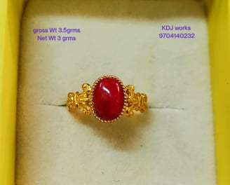 a ring with a red stone ring on top of a white box