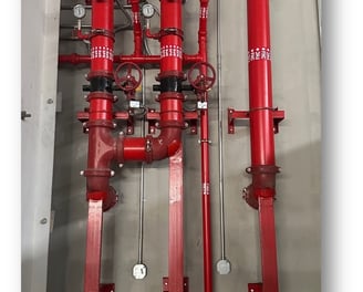 a bunch of red pipes and pipes in a room