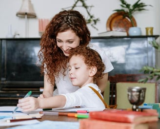 A mother and young child drawing with coloured pens.