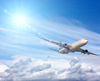 a plane flying in the sky with a bright sun shining on the clouds