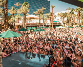 Crowd enjoying an open-bar party bus dayclub tour in Las Vegas with drinks and poolside fun.