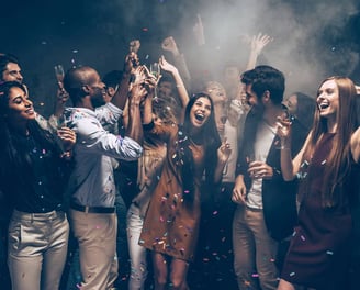 Group enjoying a lively Vegas party bus crawl with drinks and confetti.