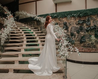 Noiva usa um elegante vestido de noiva do Ateliê Moncheri, com mangas transparentes e aplicações flo