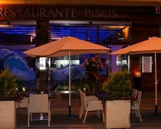 a restaurant with tables and umbrellas outside
