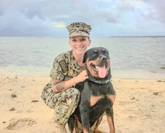 a woman in uniform is holding a dog