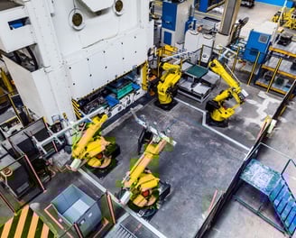 a factory with fanuc robots tending a press brake machine