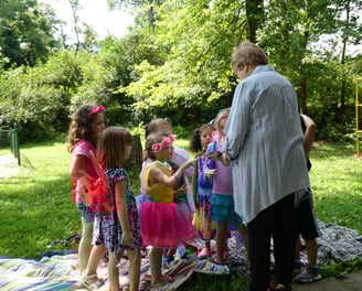 A volunteer helping children with crafts at an event in Crescent Hills Park