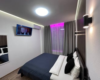 a bedroom with a television and a television