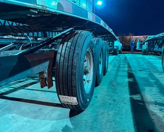 Close up view of new tires on a trailer in the blue night lights