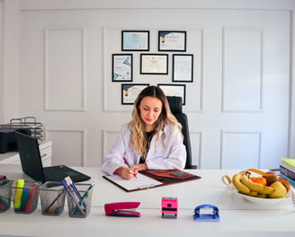 woman sitting behind desk filling out forms