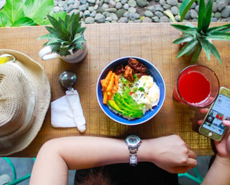 woman holding iphone while eating