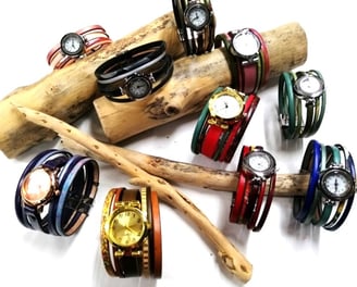 a bunch of bracelets and watches on a stick