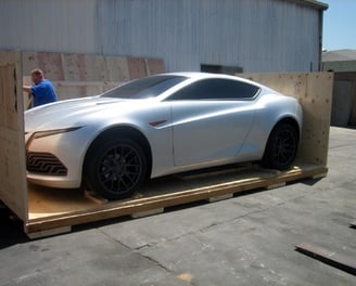 a car is being custom crated in plywood box for shipment