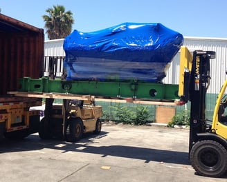 a large product with blue covered being loaded into a truck