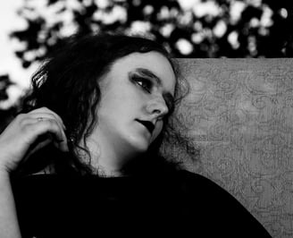 a woman with long hair and a black shirt sitting outdoor