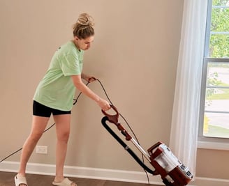 A professional cleaner pre-vacuums the hard floor