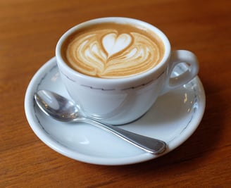 a cup of coffee with a heart shaped design on the side