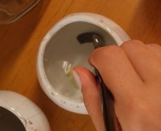 Lavando o pincel em um pote de água