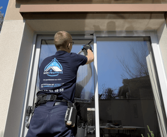 Un employé qui nettoie une baie vitrée