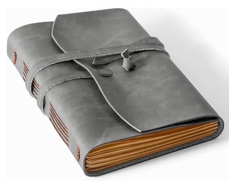 A grey leather bound journal with a leather cover.