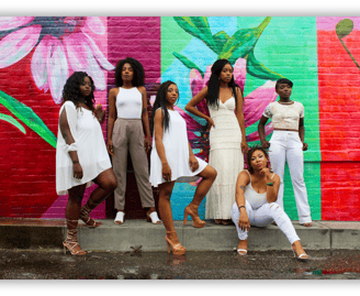 Black women standing in unity against a colorful mural, representing sisterhood, empowerment....