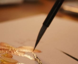 Leile pintando uma flor antúrio