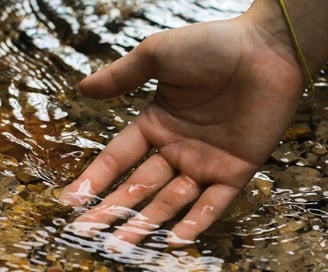Main dans l’eau claire symbolisant l’apaisement mental et la lecture subtile du champ énergétique