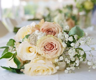 a bouquet of flowers on a table in a wedding reception
