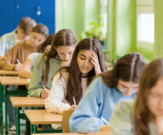 jeunes installés dans une salle, qui passent un examen écrit 