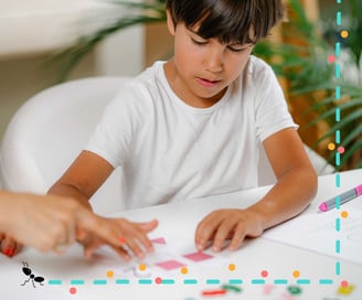 Niño resuelve tareas del test WISC-V infantil acompañado por profesional en evaluación cognitiva.