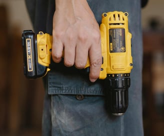 a man holding a cordless drill in his hand