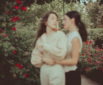 "Pareja lesbiana en el jardín con rosas, foto romántica y desenfocada celebrando su amor en una boda gay."