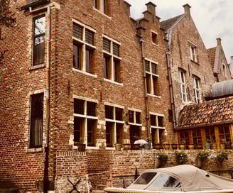 Façade de maisons flamandes en briques au bord d'un canal à Gand
