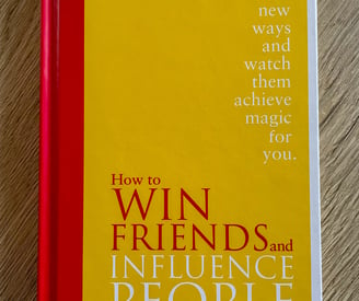 yellow book on wooden table, Dale Carnegie, how to win friends and influence people