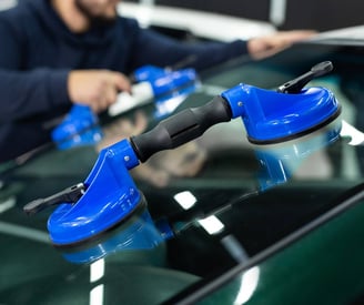 a man is cleaning a car with a blue handle
