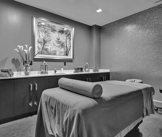 a massage room with a massage table and a large painting