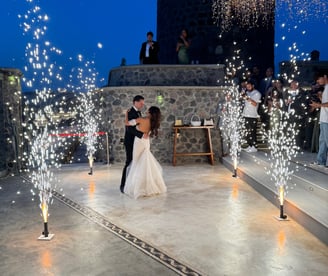 Memorable first dance moment illuminated by synchronized stage fireworks.