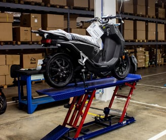 a motorcycle is parked in a garage with a lift