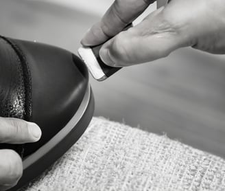 a person is removing shoe scuff with a pencil eraser