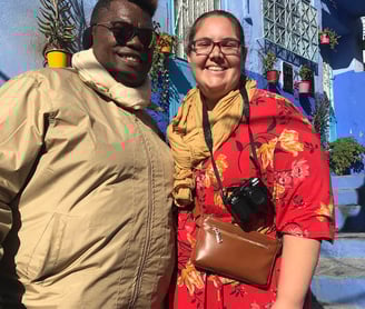 a man and woman standing in front of a blue building