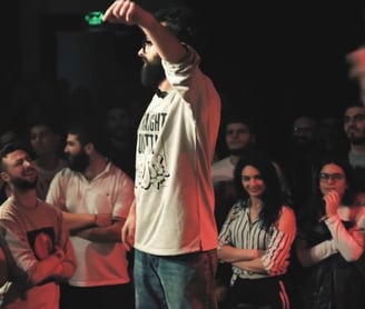 a man standing on a stage in a rap battle in the middle east
