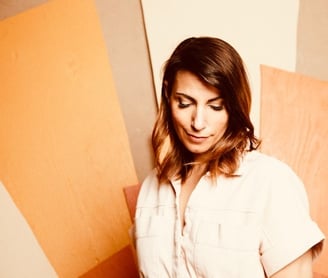 a woman in a white shirt and jeans standing in front of a wall