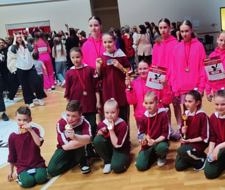 a group of young girls in pink uniforms posing for a picture