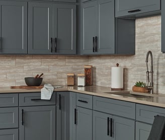 Dark gray shaker style kitchen cabinets with black pull handles