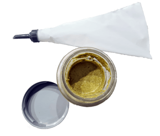 a jar of pistachio cream and a white pastry bag