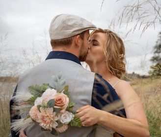 a man and woman kissing in a field